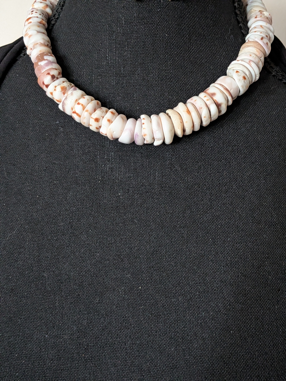 Hawaiian Puka shell necklace, commonly featuring surf-tumbled or natural chunky